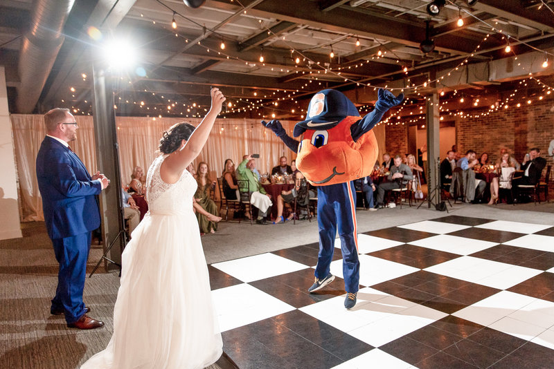 A couple celebrates the surprise arrival of Otto the Orange at their reception.