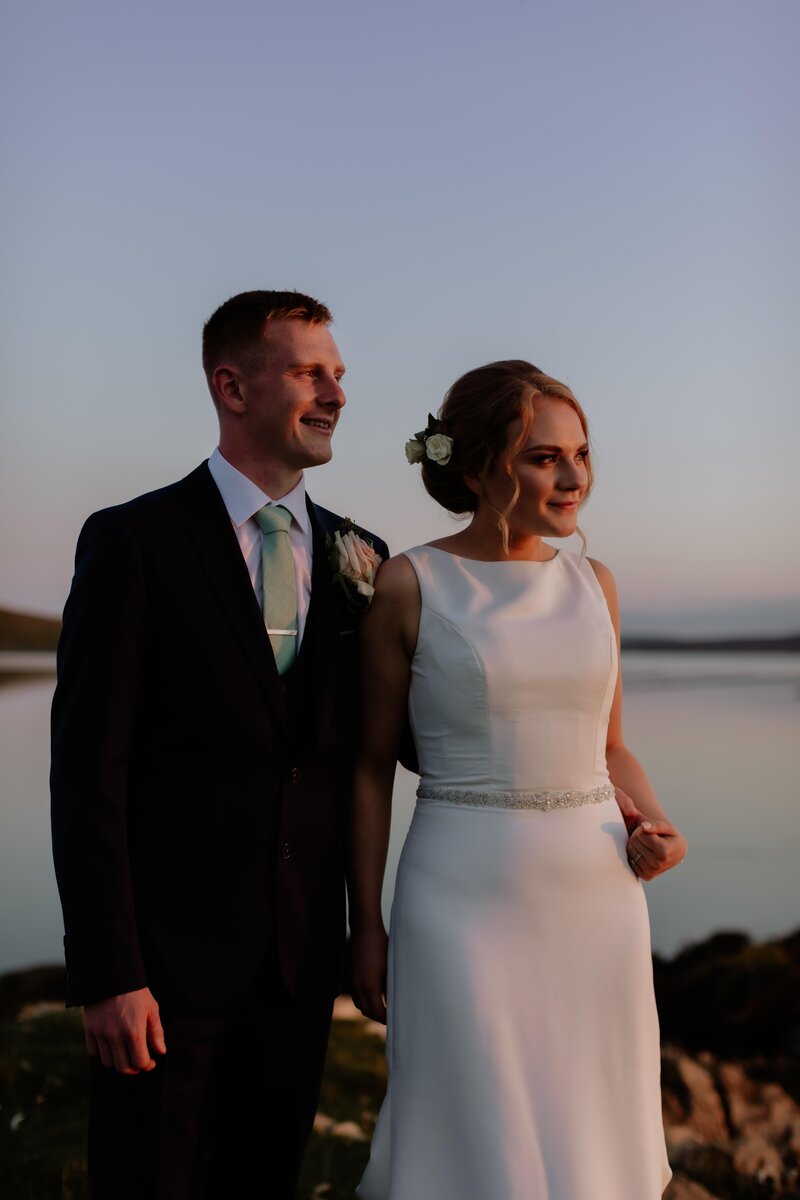 bride and groom smiling into the sunset