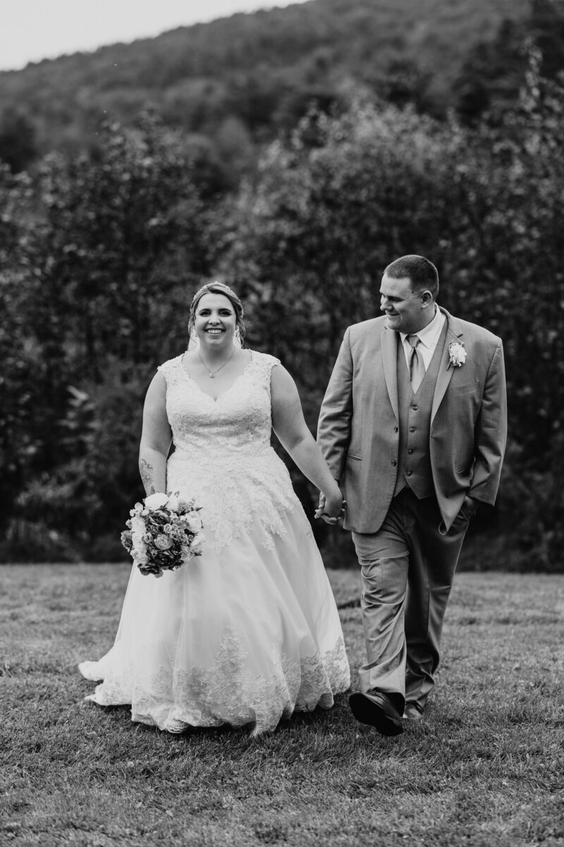 Bride and Groom smile and walk towards the camera after wedding ceremony in New Hampshire