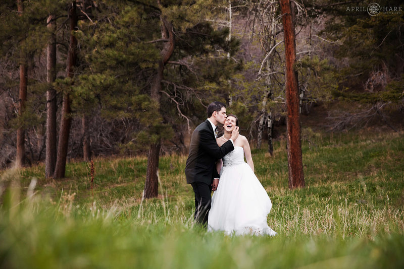 Groom kisses his bride in the forest at The Pines at Genesee