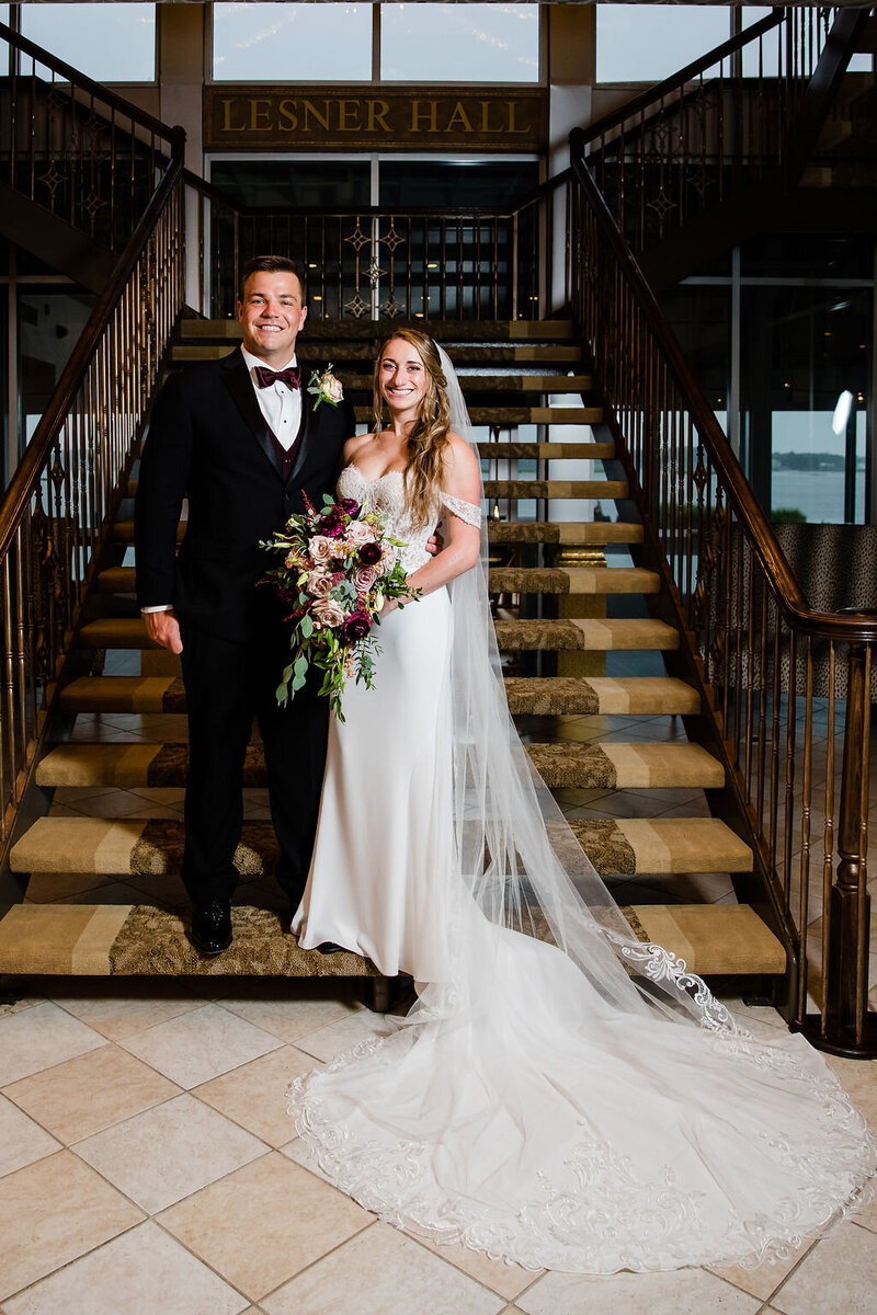 brided and groom pose on stairs at the Lesner Inn