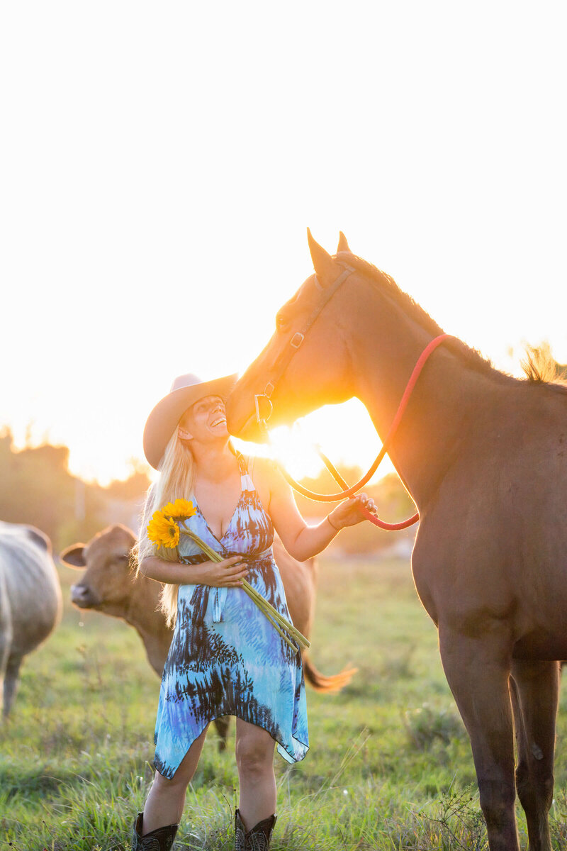 gainesville florida equine photography of a girl in a sundress holding her horse with cows in the background