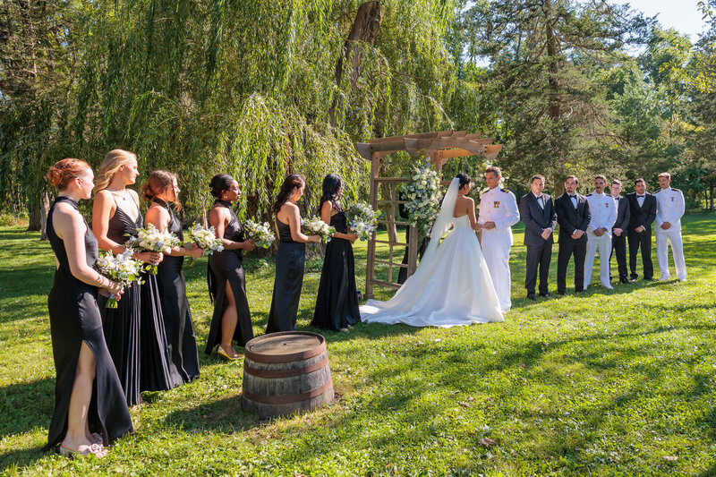 outdoor wedding ceremony with bride and groom sourrounded by their bridal parties at barnwood events in madison, winconsin