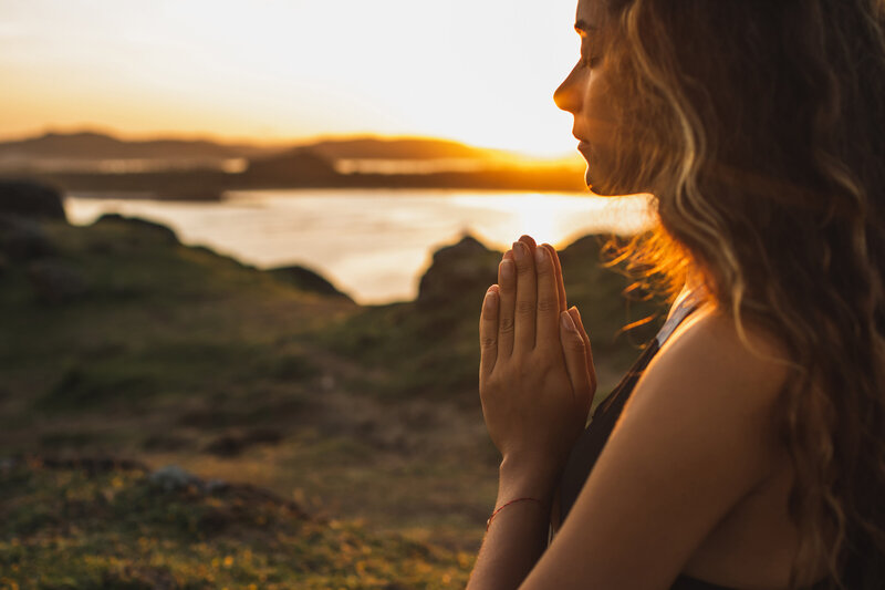 woman-praying-alone-at-sunrise-nature-background-2022-02-01-22-38-38-utc