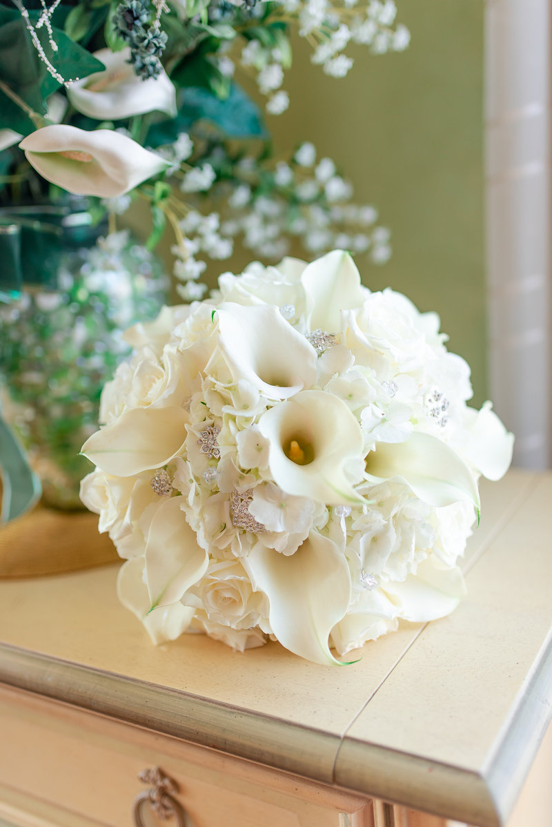 A simple white bouquet on a light tan dresser