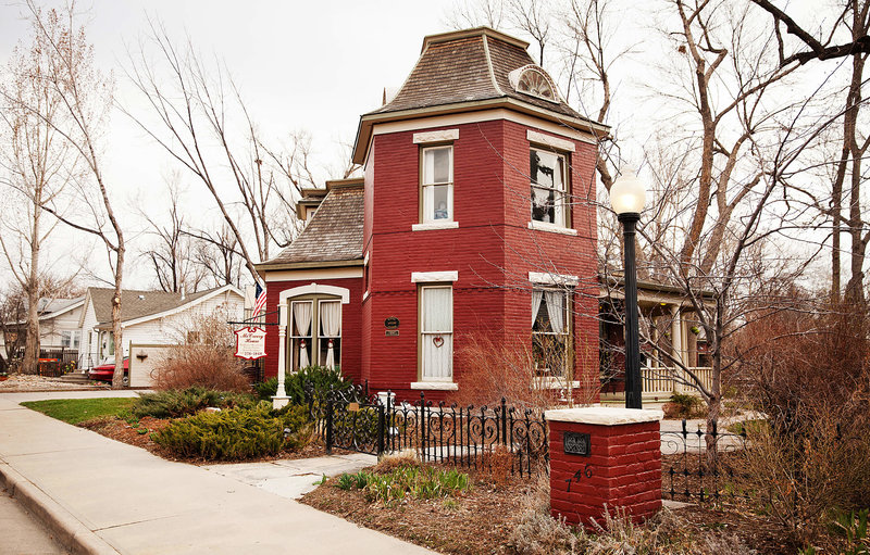 Beautiful red historic Victorian House wedding venue with a Mansard Roof in Loveland Colorado during spring