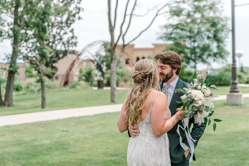 A couple embraces outside of the River Prairie Wedding Venue in Altoona, Wisconsin