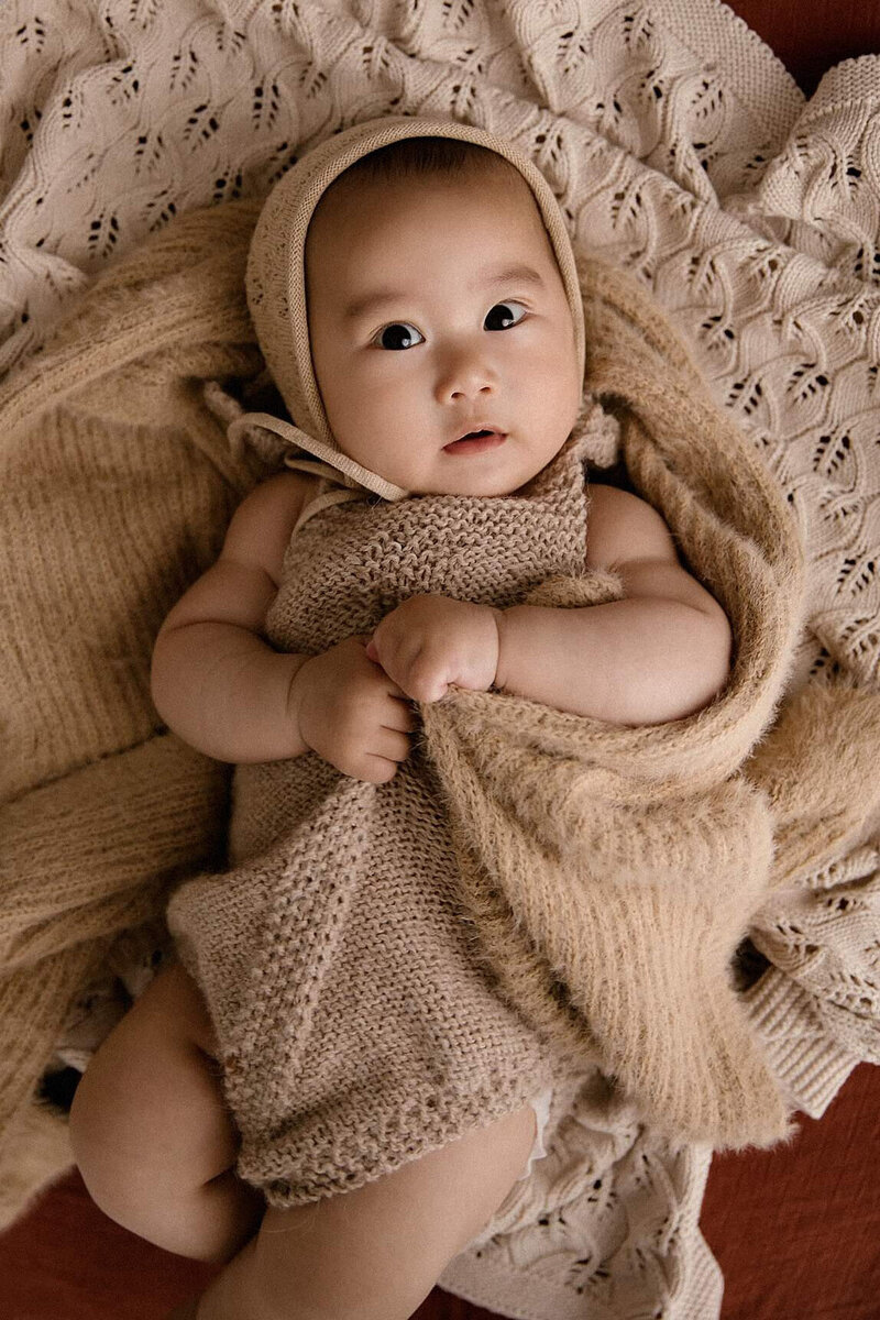Carina as a baby all rugged up in knitwear during her photoshoot with newborn and maternity photographer aimee kelly in new plymouth