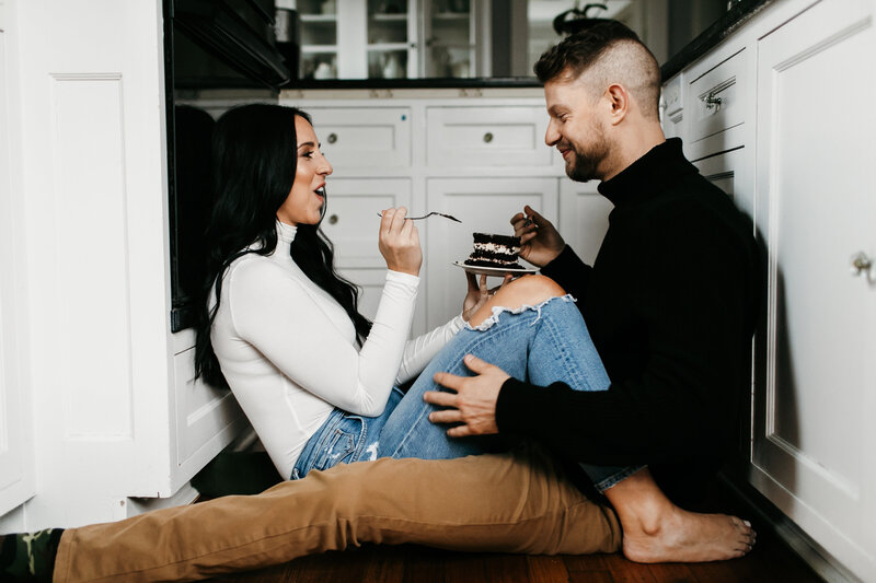 couple eating cake on the kitchen floor