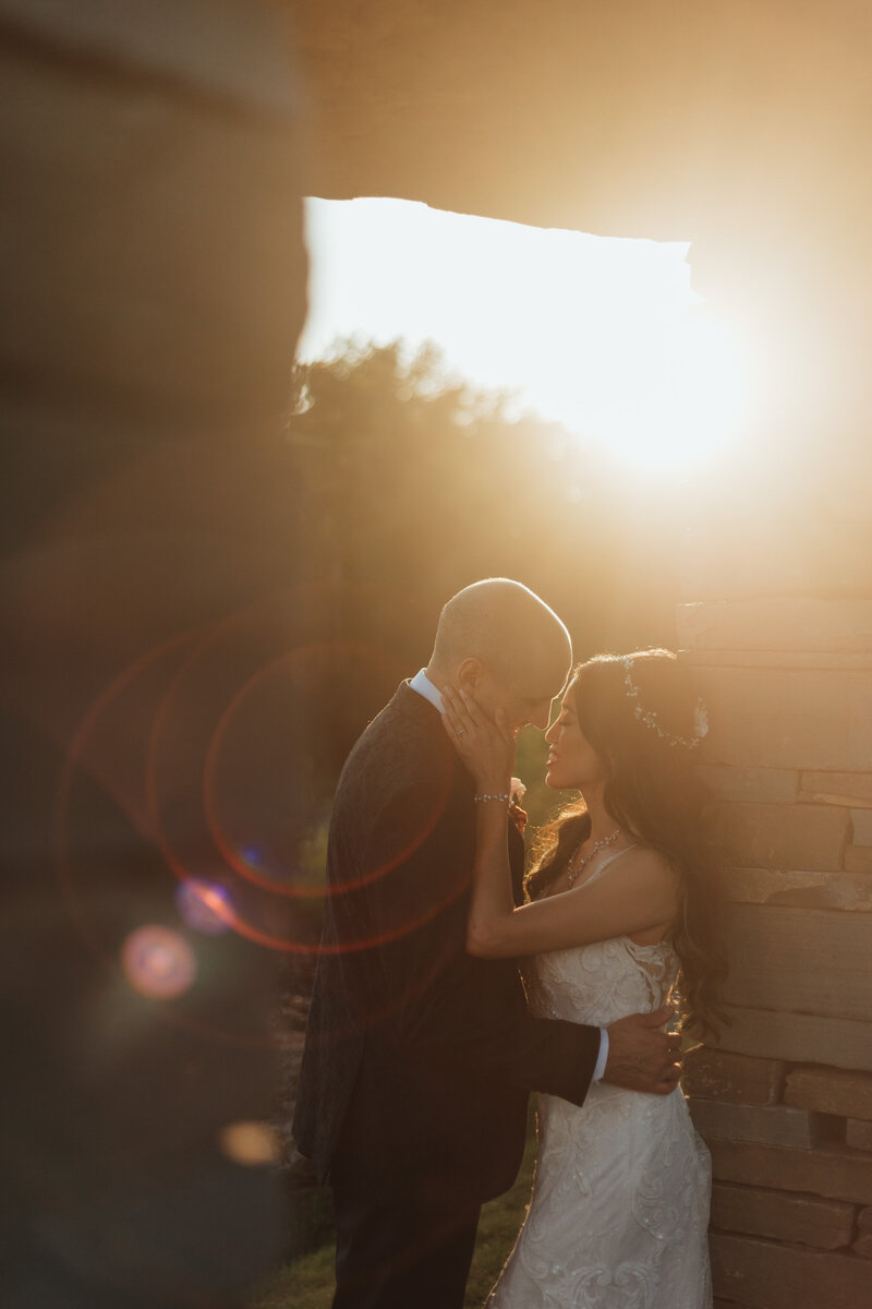 bride and groom embracing at sunset