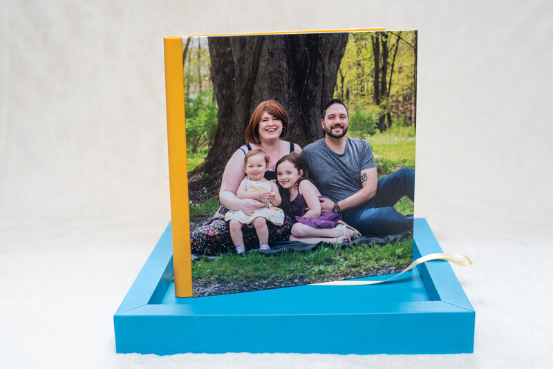 12x12 heirloom album handmade in Italy with image cover, yellow leatherette, and a blue display box.