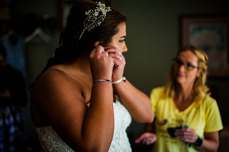 Bride puts in earrings while getting ready for Port Farms weding