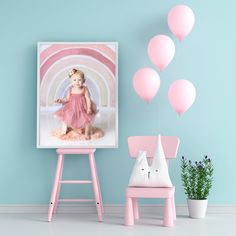 First birthday portrait shown in a frame in a girls room