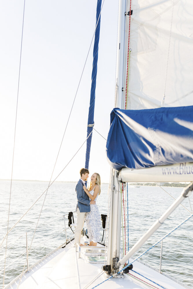 engaged couple hugging on a sailboat