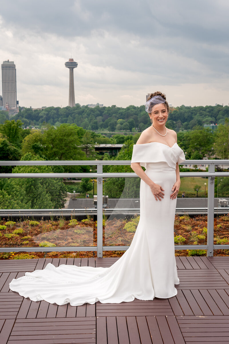 Bride standing gracefully on terrace with scenic skyline behind her – photographed by wedding photographer Niko Coric – Lumen Clarity Media