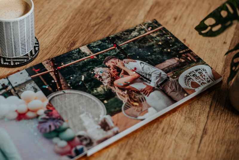 A top down photo of an open photo spread showing a couple in confetti