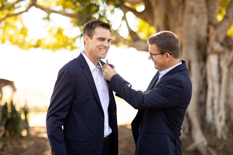 Best man fixing groom's boutonniere