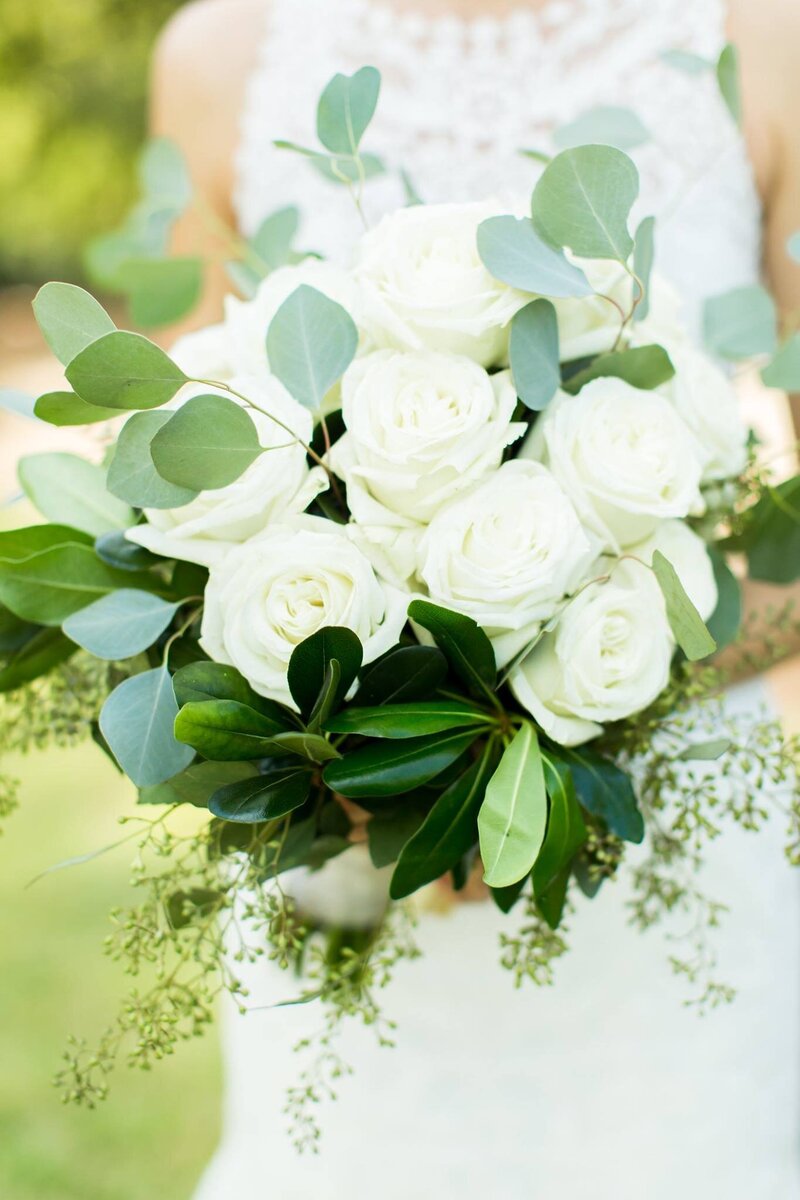 white roses and eucalyptus with seeds in a bridal bouquet