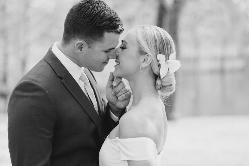 groom leaning in for a kiss holding bride's chin