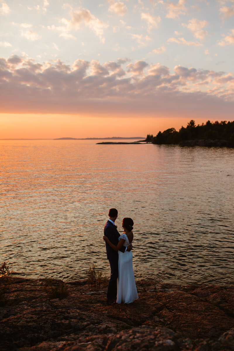 couple overlooks gorgeous pink and orange sunset during their muskoka elopement