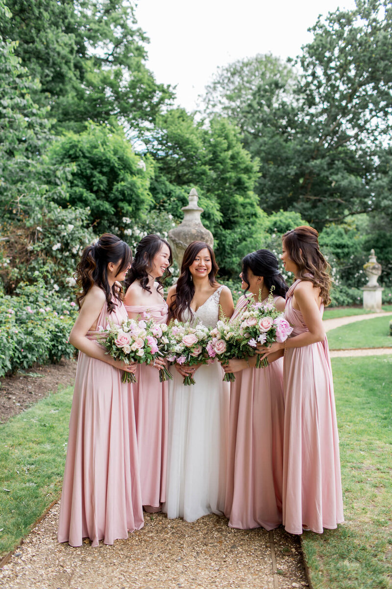 Bride and her bridesmaids wearing pink long dresses at Chiswick House and Gardens, London