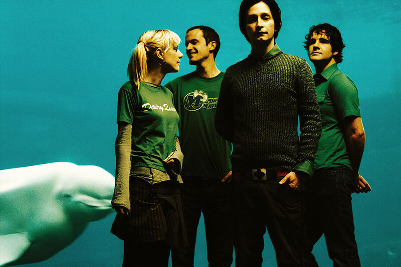Band portrait Limblifter standing in front of beluga whale aquarium