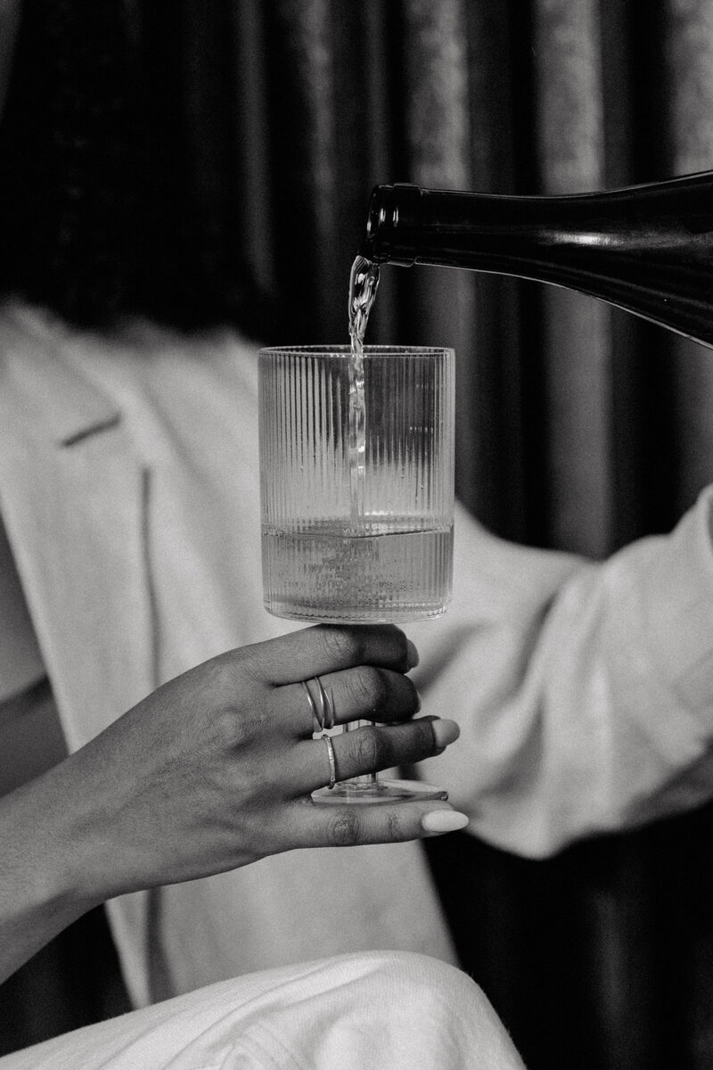 Black and white photo of woman pouring water into a glass