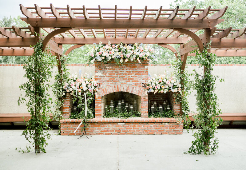 a fireplace decorated with pink florals for a wedding
