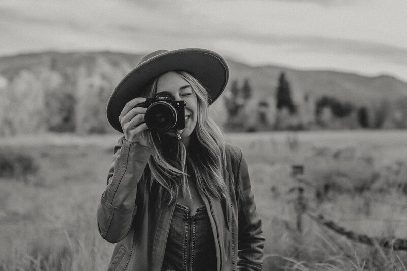 Christina landini is holding up her camera smiling