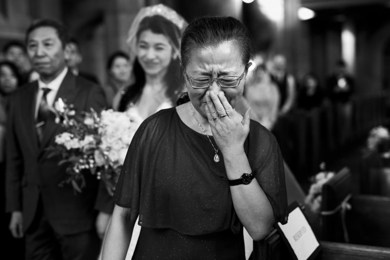 Mother reacting to bride coming down aisle