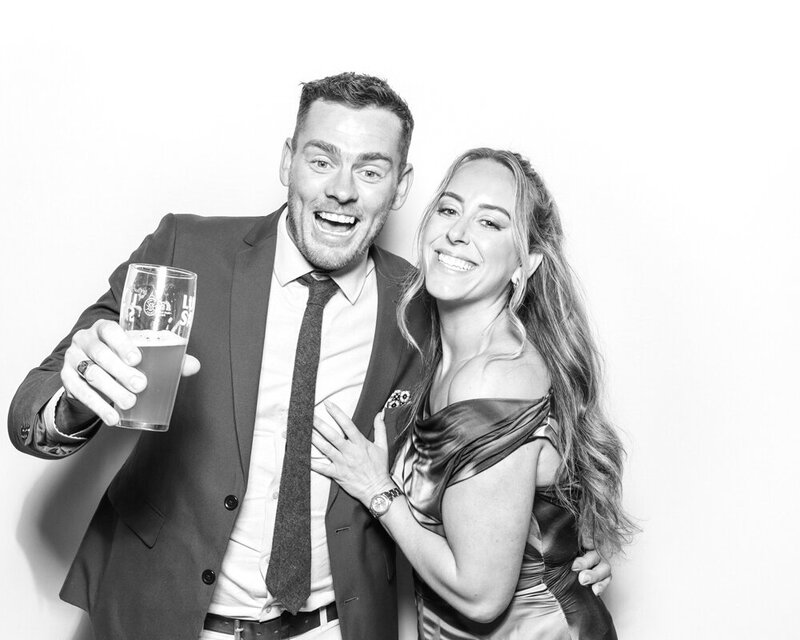 couple posing against a white backdrop for a b&w filter during a kardashian glam photo booth hire