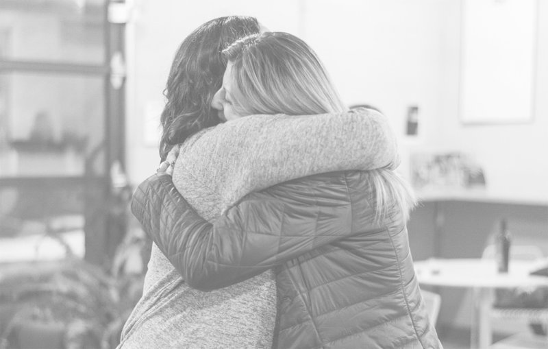 Founder Amanda Clark hugs a fellow caregiver at a Cocktails & Chemo event
