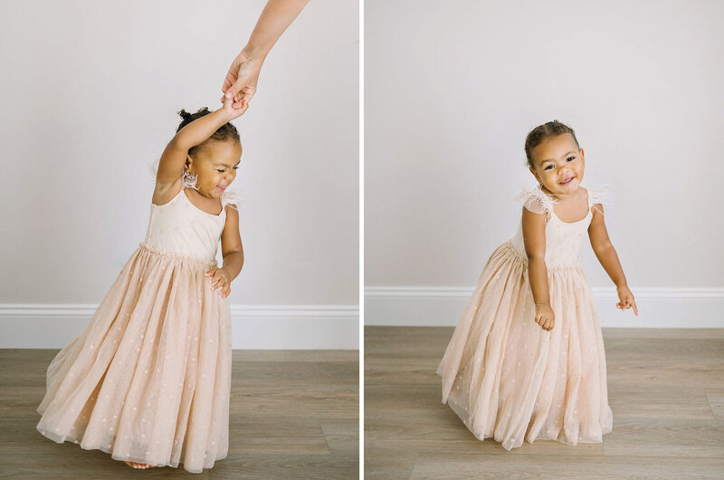 A child in a flowy pink  tulle dress dances during her child photography session