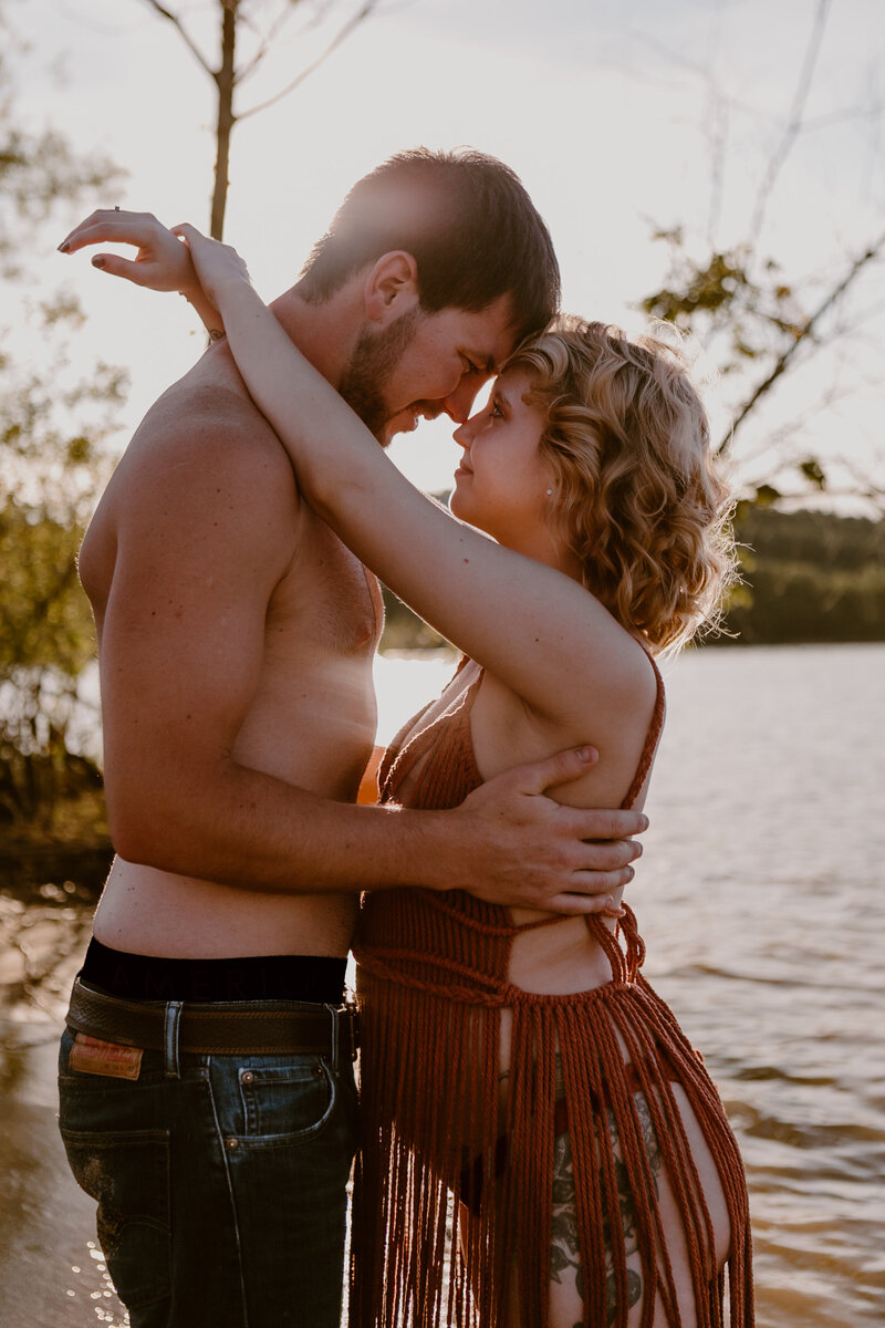 Photo of a pregnant woman and her husband at the lake during their maternity photos in Bloomington, Indiana