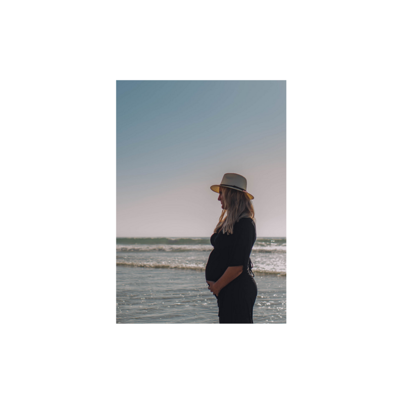 a woman taking her maternity photos on the beach