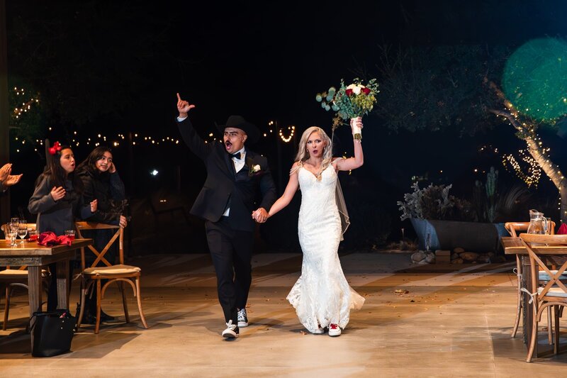 Bride and groom cheering and making their grand entrance to their rustic Carriage House reception hall at Galway Downs by Wedgewood Weddings in Temecula.