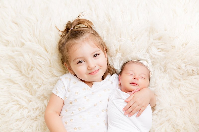 Sibling girl with newborn sister