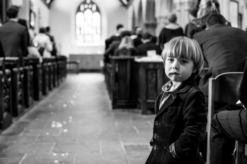 Young wedding guest at the back of a church wedding