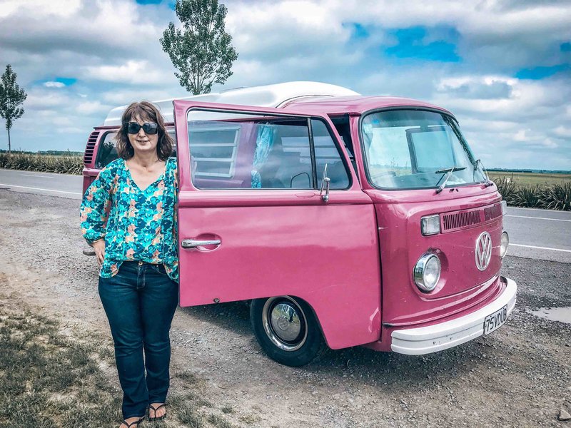 Lynda standing beside kombi van Pippi on roadside in Canterbury, New Zealand on a road tirp.