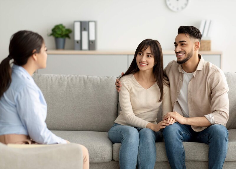 Man and woman sitting on a couch talking to a therapist