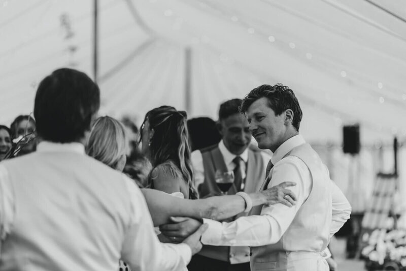Wedding guests enjoying themselves under the marquee