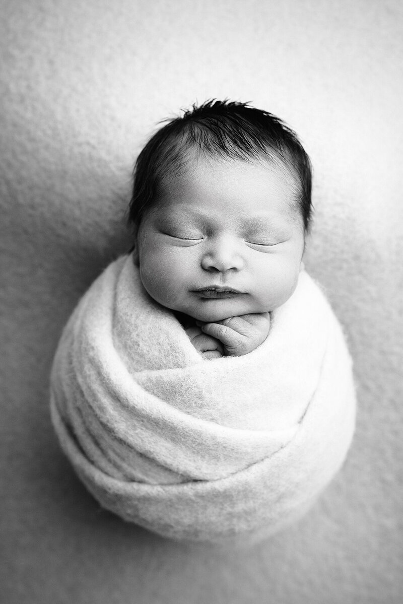 Black and white portrait of newborn baby swaddled in Jacksonville, FL.