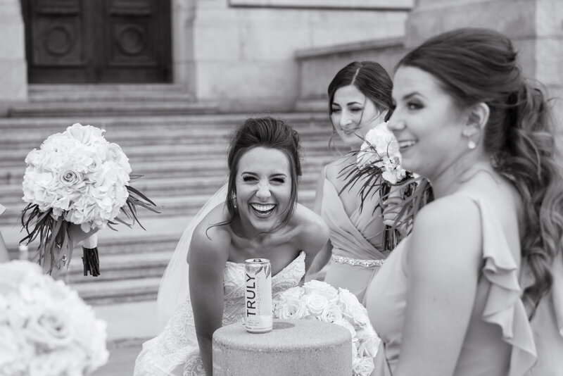 Cleveland bride and her bridesmaids shares laughs and memories on her wedding day, behind The Old Courthouse located in Cleveland Ohio. Photo taken by Aaron Aldhizer