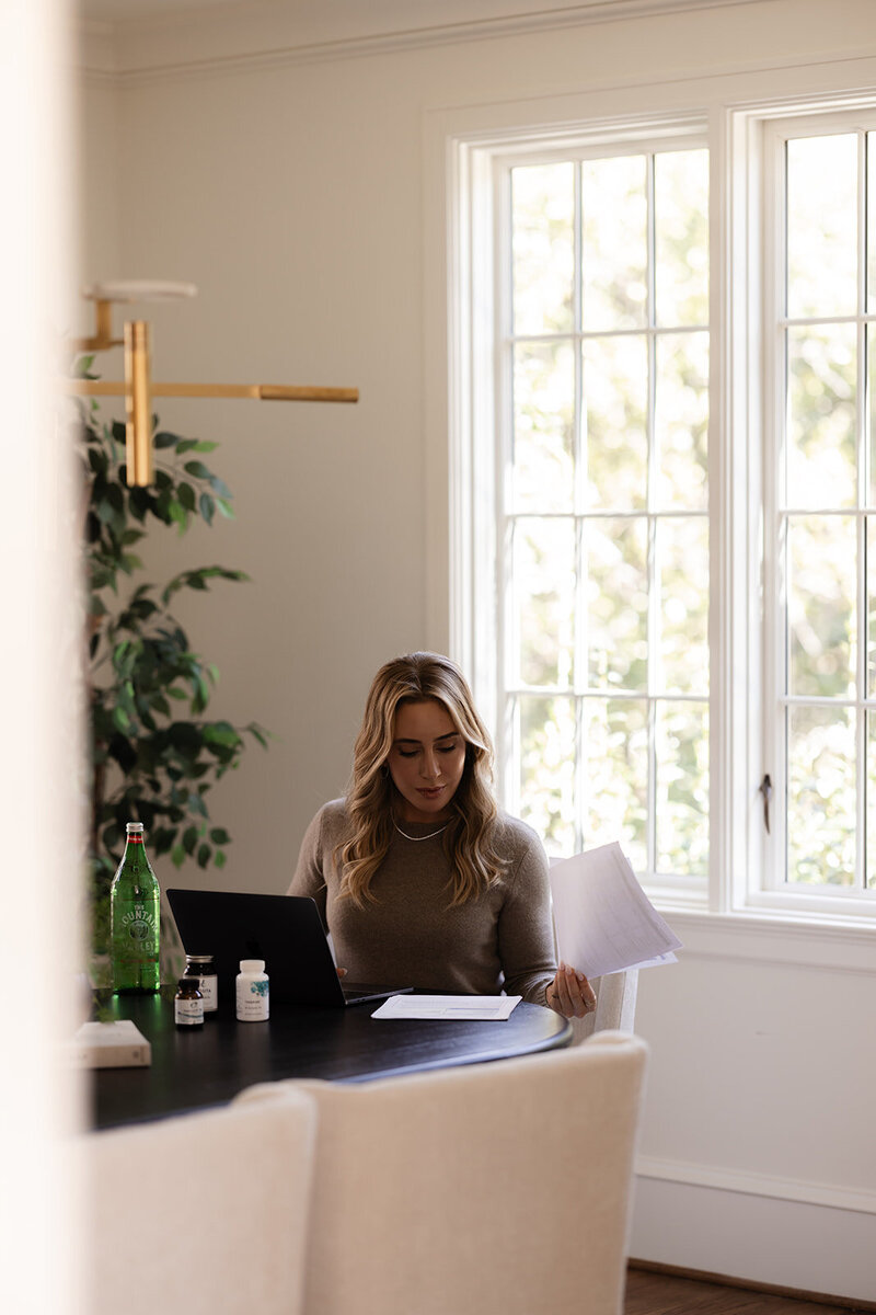 Functional dietician and nutritionist Tracy Greenstein reviewing client assessments and lab notes at her desk