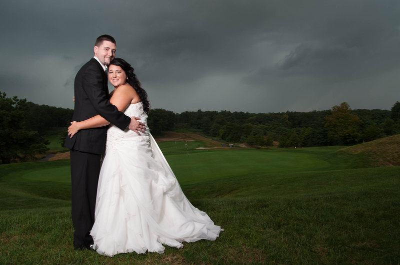 bride and groom under stormy skies