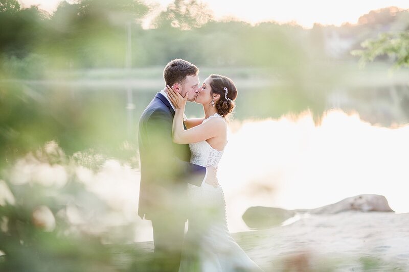 kissing by lake by Knoxville Wedding Photographer, Amanda May Photos