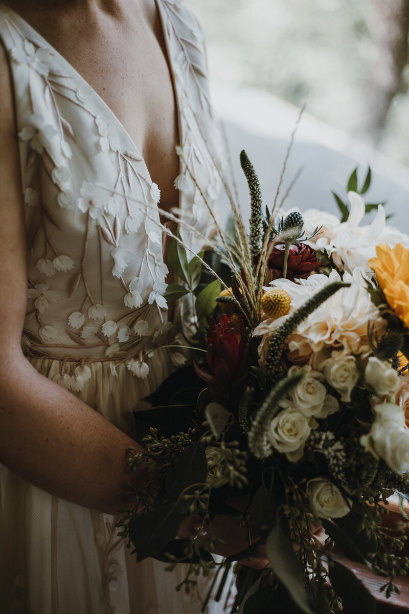 bride holding bouquet of colorful flowers