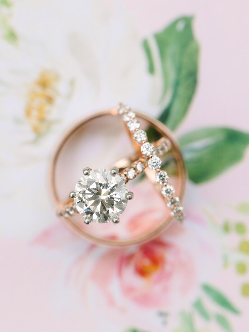 Close up of diamond wedding rings on a floral background