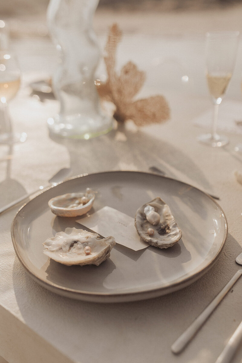 A close-up of a dining setup with half-eaten oysters on a plate.