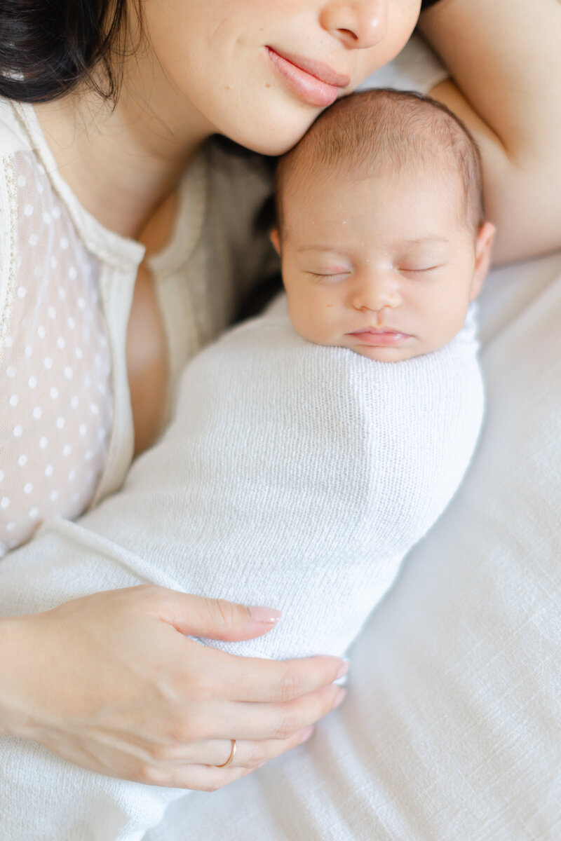 Mother holds her sleeping newborn baby